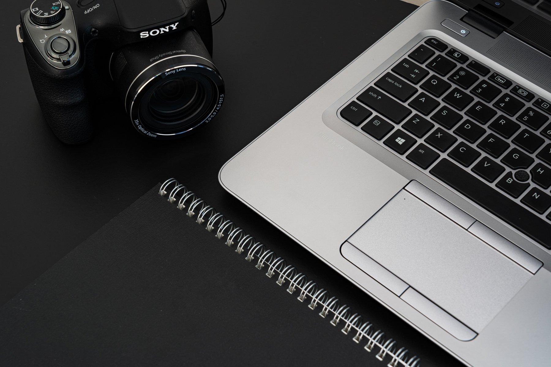 Black Camera Beside A Laptop